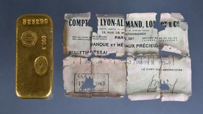 a gold bar and a piece of paper on a table