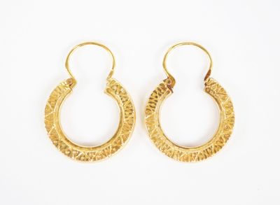 a pair of gold hoop earrings on a white background
