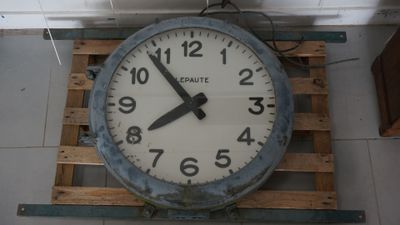 a large clock hanging from the ceiling of a building