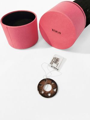louis vus pink and black box with a coin and a tag on it