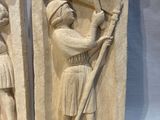 pair of stone reliefs of a man with a spear and a woman with a sword