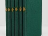 un lot de quatre livres verts ornés de bordures dorées