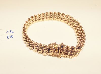 a close up of a gold bracelet with a chain around it