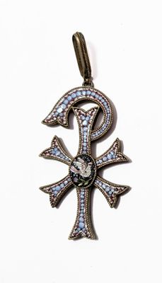 une photo d'un pendentif en forme de croix égyptienne orné de pierres bleues et blanches