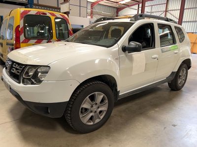 a white dacia parked in a garage next to a yellow van