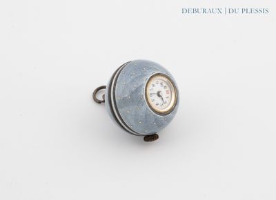 un anneau renfermant une horloge, posé sur une surface blanche