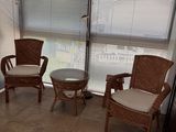 two wicker chairs and a table in the corner of a room