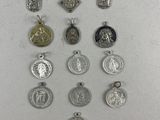 a close up of a group of silver and gold medals on a white surface