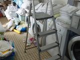 une photo d'une buanderie avec une machine à laver et une échelle