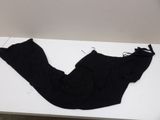 black pants on a white table with a pair of scissors on it