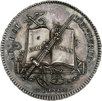 a close up of a coin with a sword and a book on it