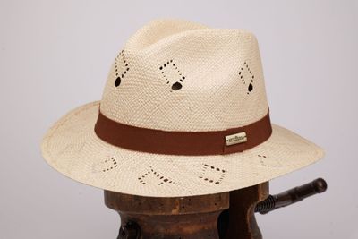 un chapeau de paille orné d'un ruban en cuir, posé sur un porte-chapeaux