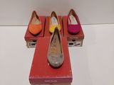 trois paires de chaussures sont posées sur une boîte rouge