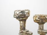 two silver candlesticks sitting next to each other on a table
