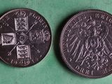 two silver coins on a green surface with a green background