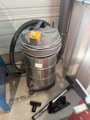 un aspirateur et des outils posés par terre dans une pièce