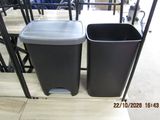 two trash cans sitting next to each other on the floor