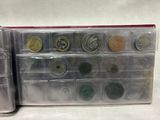 an assortment of coins in a plastic case on a white surface