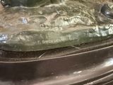 a bronze statue of a dog laying on top of a table