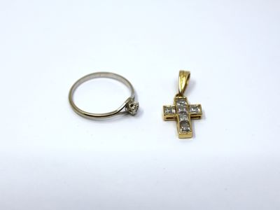 an image of a ring and a cross pendant on a white surface