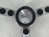 a silver steering wheel with black dots on it