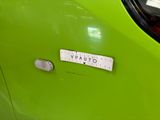a close up of a green car with a sticker on it ' s side