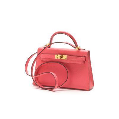 the small pink bag is on a white surface