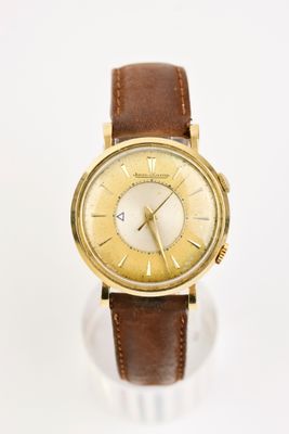 une photo d'une montre-bracelet en or avec un bracelet en cuir marron
