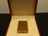 an image of a gold lighter in a red box on a table