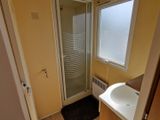 une salle de bains équipée d'une douche, d'un lavabo et d'une fenêtre