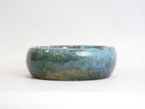 a blue and green bowl sitting on a white surface