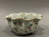 a white bowl with flowers on it sitting on a table