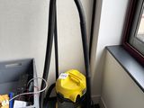 un aspirateur et une boîte posée par terre près d'une fenêtre
