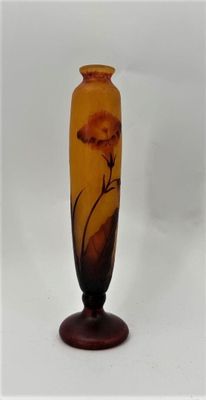 a glass vase with a flower on it sitting on a table