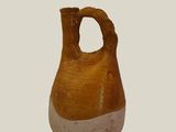 a brown and white vase with a hole in it