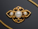 an image of a gold necklace with a pearl and blue stones