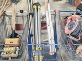 Plusieurs caddies sont alignés dans un garage où se trouvent des outils