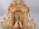 a gold clock with a figurine of a woman in a dress