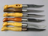 six different types of knifes are lined up on a table