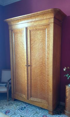 une grande armoire en bois dans le coin d'une pièce