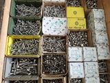 many boxes of screws in a box on the floor