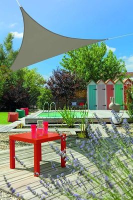 une table rouge posée sur une terrasse en bois près d'une piscine