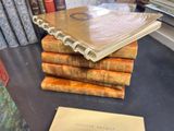 many books stacked on top of each other on a table
