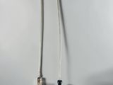 a black object on a white surface with a silver cord