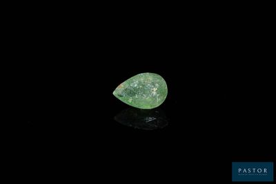 a close up of a green diamond on a black surface