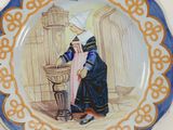 a plate with a picture of a woman sitting at a table