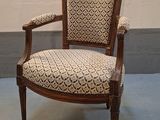 une photo d'une chaise dont l'assise est recouverte d'un tissu à motifs, dans une pièce