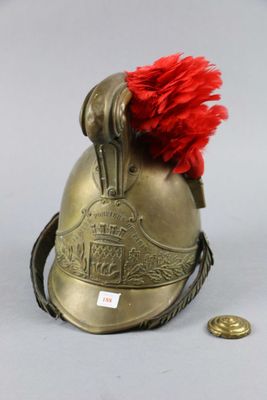 a gold helmet with a red pom pom on top of it