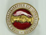 an image of a gold and red badge with a hand shaking hands