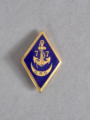 une image représentant un pin's bleu et doré orné d'une ancre